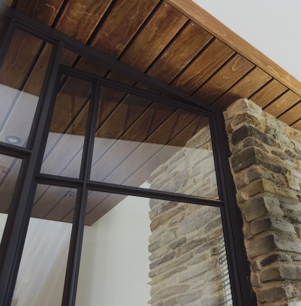a black steel door inside a home with exposed brick