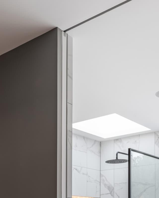 sliding pocket door in a bathroom showing split finishes including tiles