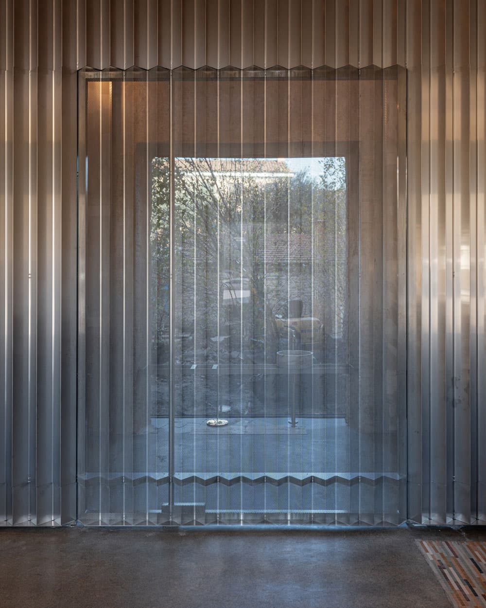 an internal pivoting door made from perforated aluminium blends seamlessly with the matching screen at the Caffè Nazionale