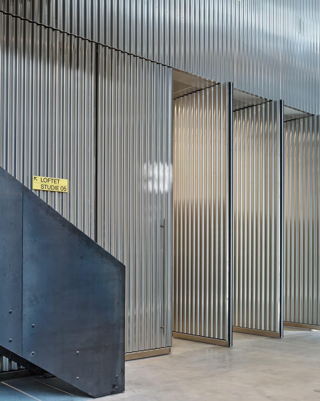 huge pivoting doors using FritsJurgens System M+ hinges - the doors are clad in aluminium in a large dance studio and theatre